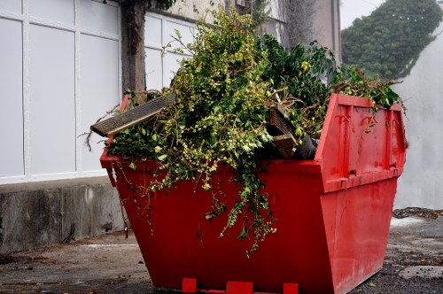 Team using PPE while loading a skip for waste removal.